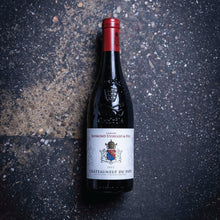 Load image into Gallery viewer, Wine bottle with a red label on a dark textured surface