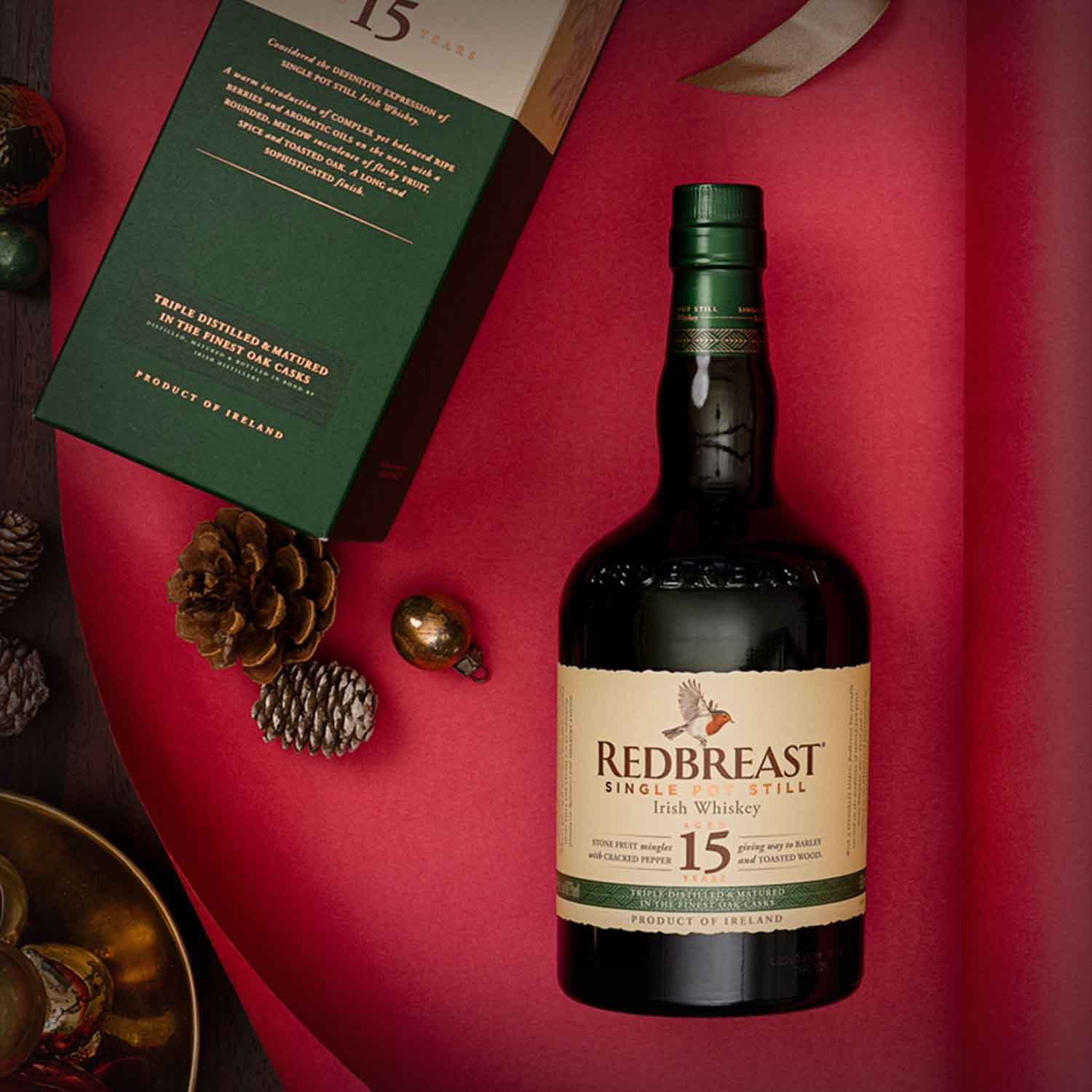 Load image into Gallery viewer, Redbreast whiskey bottle on a red surface with some Christmas decorations