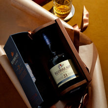Load image into Gallery viewer, Redbreast 21 year old whiskey bottle in a gift box with a glass of whiskey in the background