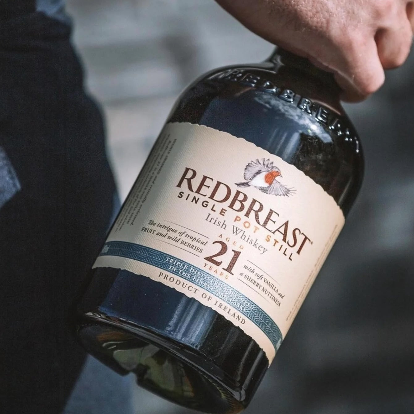 Load image into Gallery viewer, A man holding a bottle of Redbreast 21YO Irish Whiskey