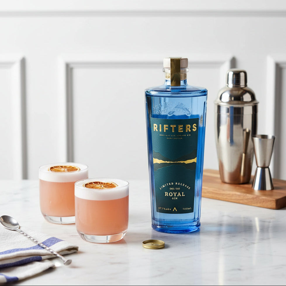 Load image into Gallery viewer, Bottle of Rifters Royal Navy Strength Gin with two cocktails on a marble surface