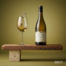 Load image into Gallery viewer, Bottle of Rockburn Chardonnay white wine with a glass of wine on a wooden stand against a green background.