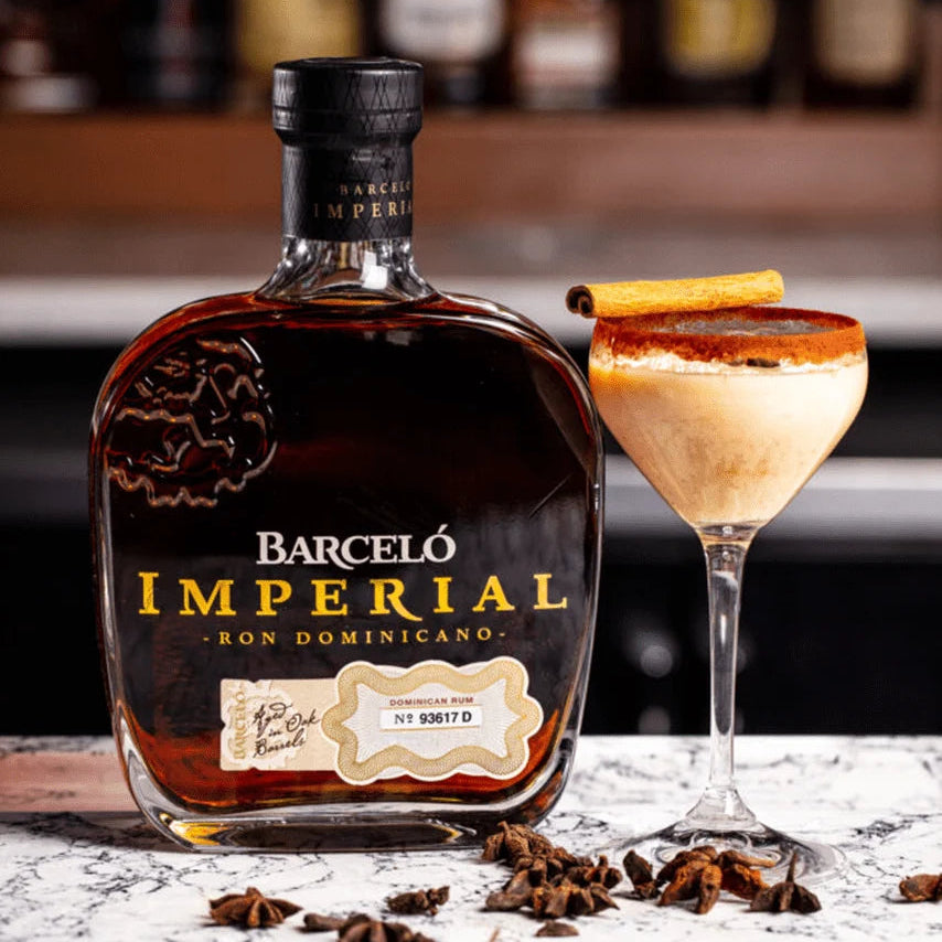 Load image into Gallery viewer, Barceló Imperial rum bottle with a cocktail on a bar counter