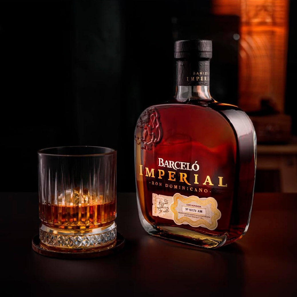 Load image into Gallery viewer, Barceló Imperial rum bottle with a glass of rum on a dark background