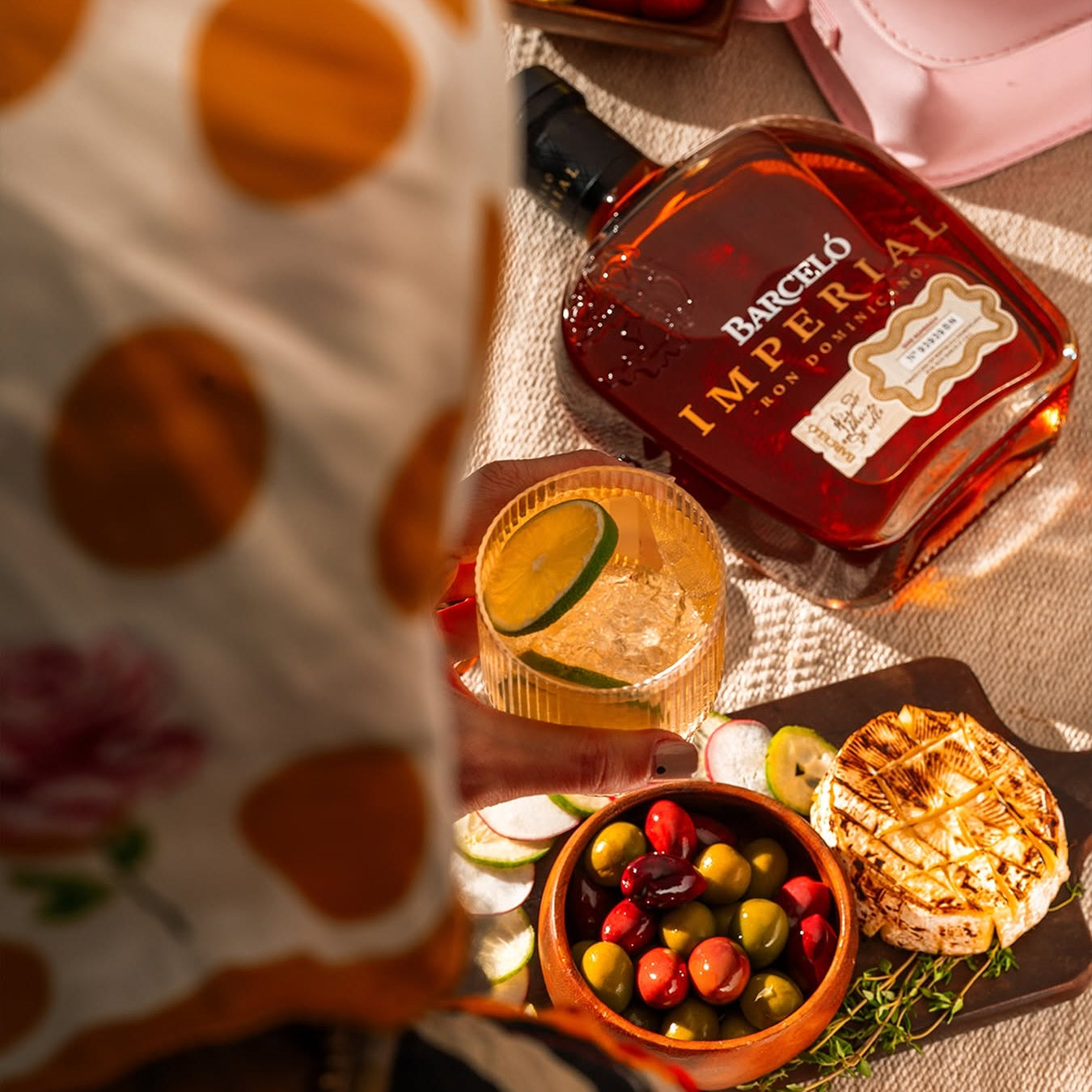 Load image into Gallery viewer,  Barcelo rum bottle with a cocktail and snacks on a table.