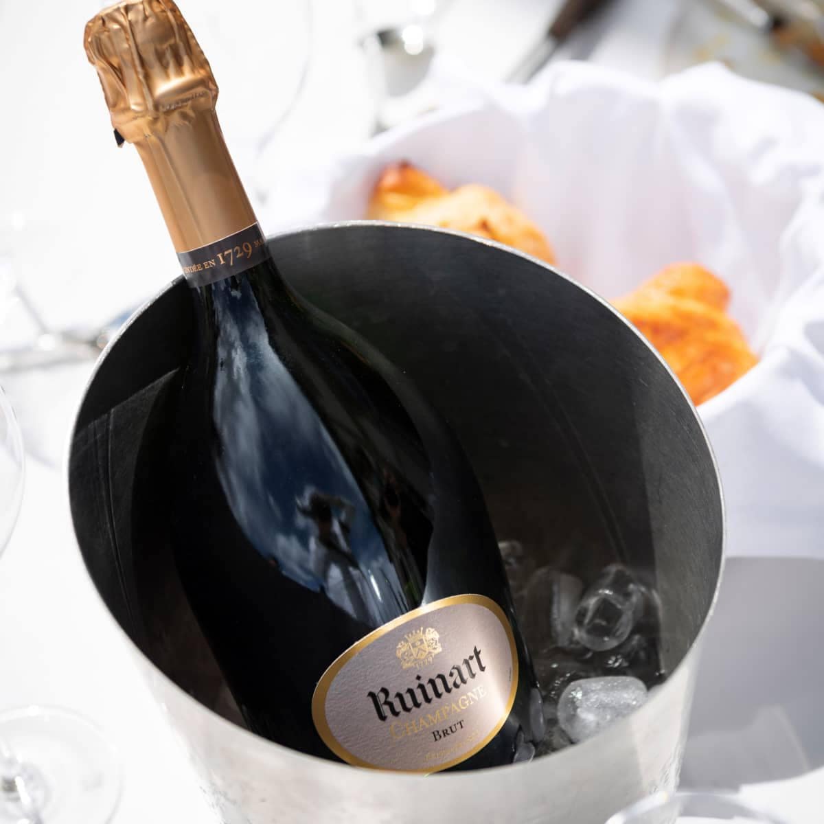 Load image into Gallery viewer, A bottle ofRuinart R de Ruinart Champagne in a ice bucket
