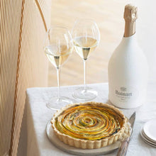 Load image into Gallery viewer, Dessert table with a tart, two glasses of champagne, and a bottle of Ruinart R de Ruinart Champagne on a white surface.