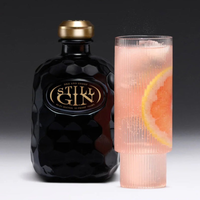 Load image into Gallery viewer, Still Gin bottle and cocktail with 'West Coast Paloma' text on a dark background