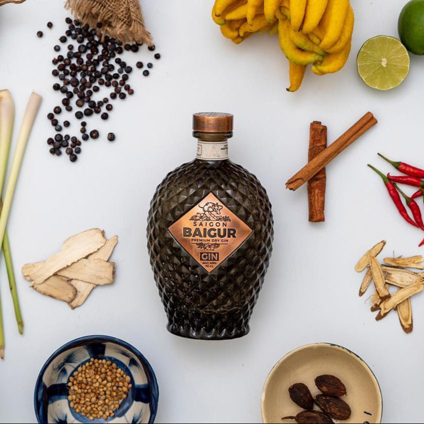Load image into Gallery viewer, Saigon Baigur Vietnamese Premium Dry Gin bottle surrounded by spices and ingredients on a white background