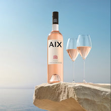 Load image into Gallery viewer, Magnum Bottle of AIX rosé wine with two glasses on a stone platform against a blue sky.