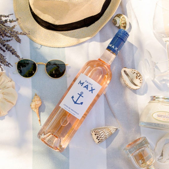 Lifestyle image of a bottle of Saint Max Cotes De Provence Rose in summer setting on table