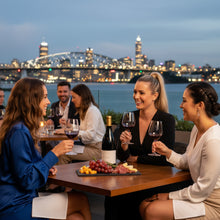 Load image into Gallery viewer, Group of people enjoying a bottle of Sam Harrop Onetangi Waiheke Island syrah wine and snacks with a city skyline in the background