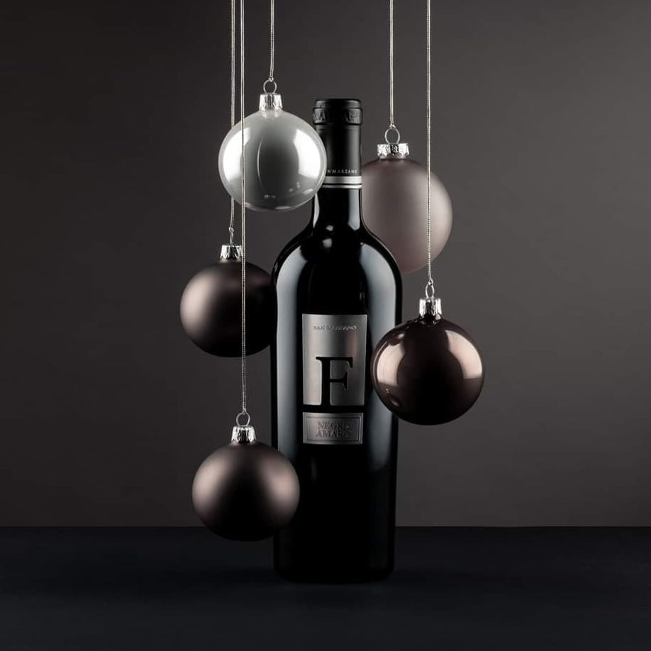 Load image into Gallery viewer, A bottle of San Marzano F Puglia Negroamaro red wine with Christmas tree decoratve balls hanging around it