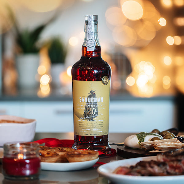 Load image into Gallery viewer, A bottle of Sandeman 20 year old tawny port and some food on a table 