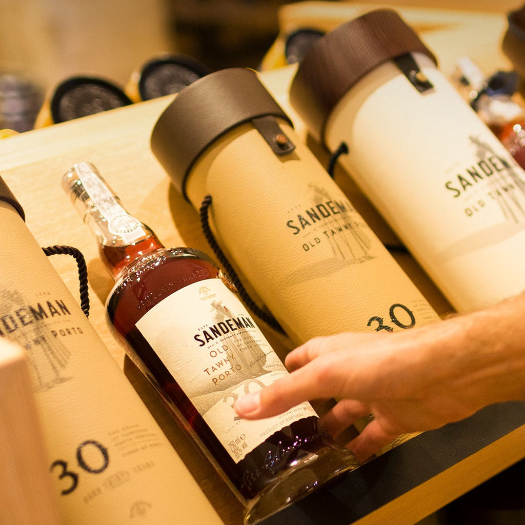 Sandeman wine bottles and packaging on a wooden surface
