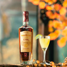 Load image into Gallery viewer, Bottle of Santa Teresa 1796 rum with a cocktail garnished with a lime wedge on a decorative surface.