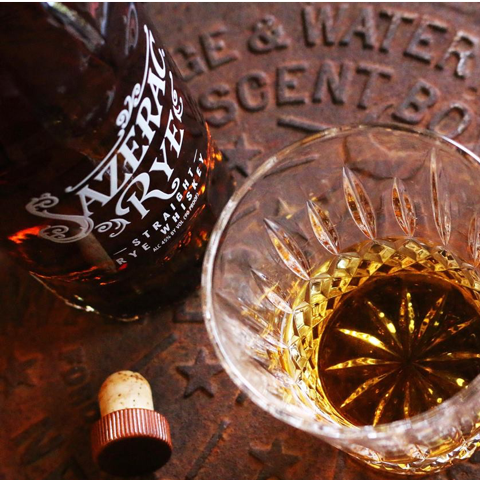 Load image into Gallery viewer, Sazerac Rye bottle with a glass of whiskey on a textured surface
