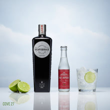 Load image into Gallery viewer, Bottle of Scapegrace Classic gin, East Imperial tonic water bottle, and a glass with lime and ice on a reflective surface.