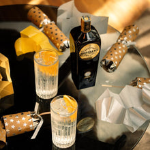 Load image into Gallery viewer, Two glasses of gin and tonic with a bottle of Scapegrace Gold Gin on a reflective surface.