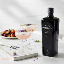 Load image into Gallery viewer, Scapegrace Black Gin bottle with pink cocktails garnished with lavender on a white surface.
