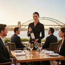 Load image into Gallery viewer, Waitress serving Serafino-Sharktooth-Shiraz wine to four people at an outdoor dining table with a bridge in the background