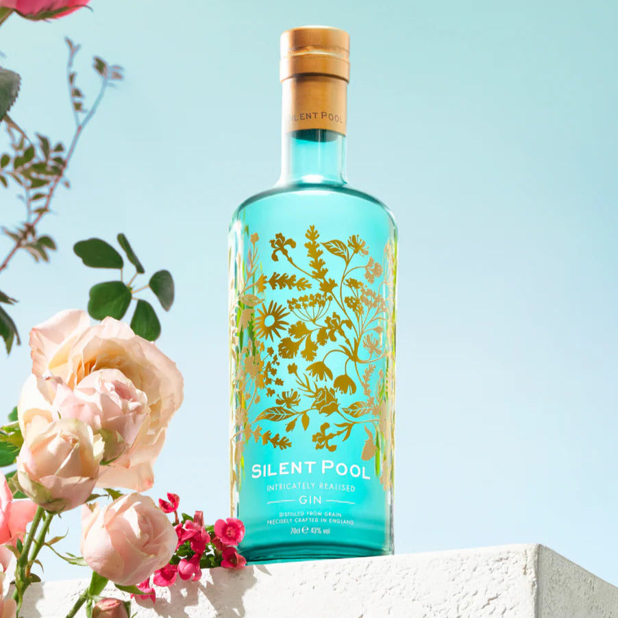 Load image into Gallery viewer, Bottle of Silent Pool gin with floral design against a light blue background with roses.