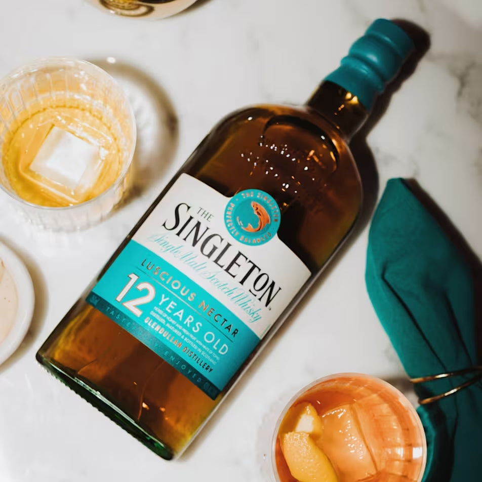 Load image into Gallery viewer, Singleton of Dufftown 12 Year Old Single Malt Scotch Whisky bottle with cocktails on a marble surface