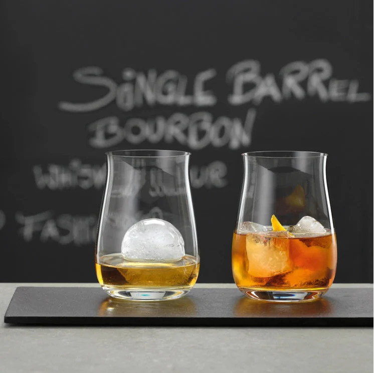 Load image into Gallery viewer, Two glasses of bourbon with ice cubes on a bar counter, with 'Single Barrel Bourbon' text in the background.