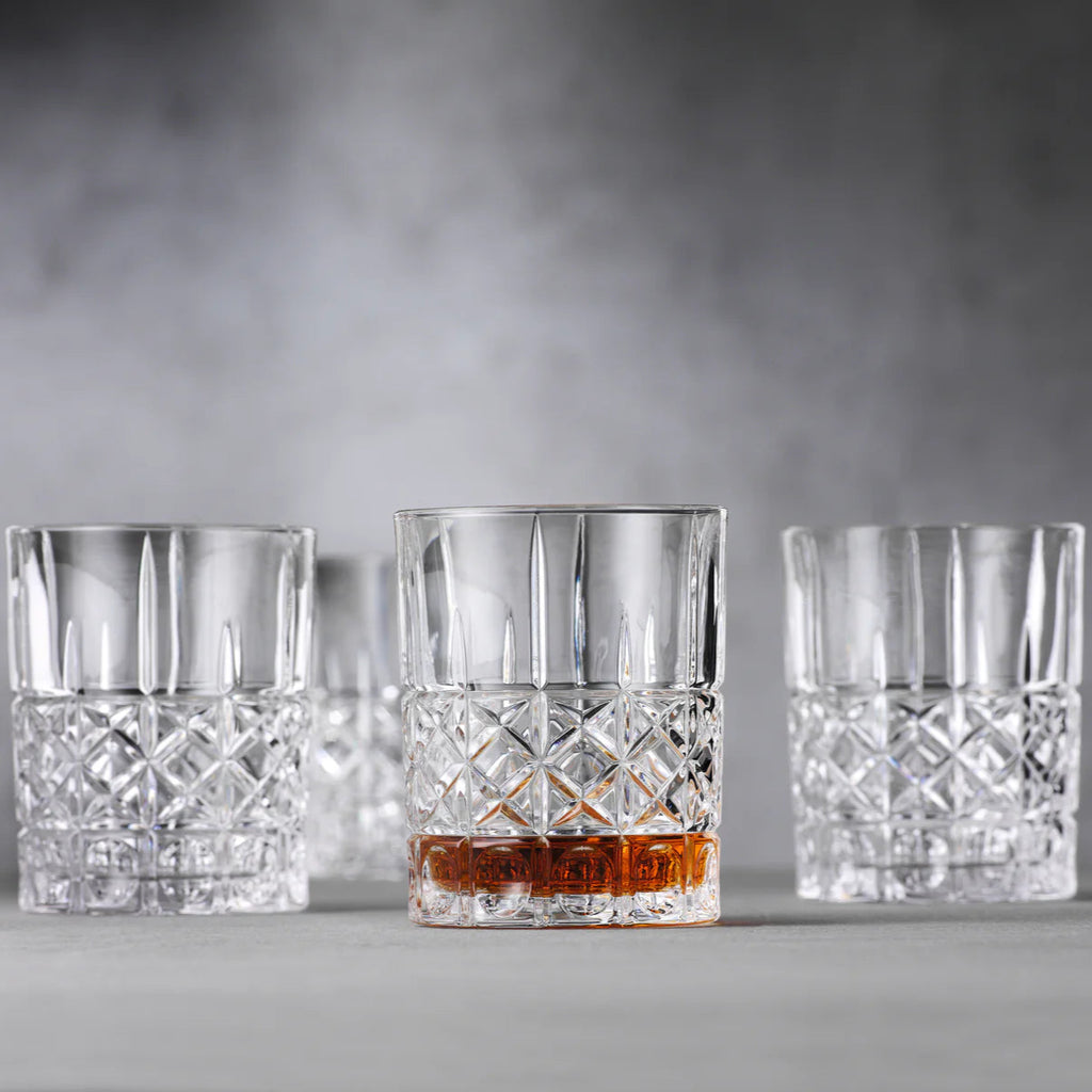 Three crystal glasses with a drink on a gray surface and background