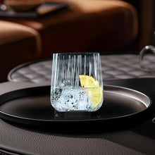 Load image into Gallery viewer, Clear glass with lemon wedge on a black tray, Spiegelau logo visible