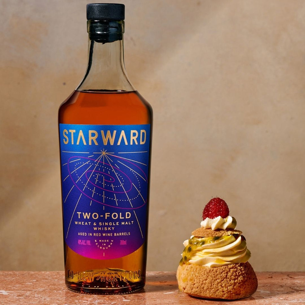 Starward Two-Fold whiskey bottle with a dessert on a wooden surface