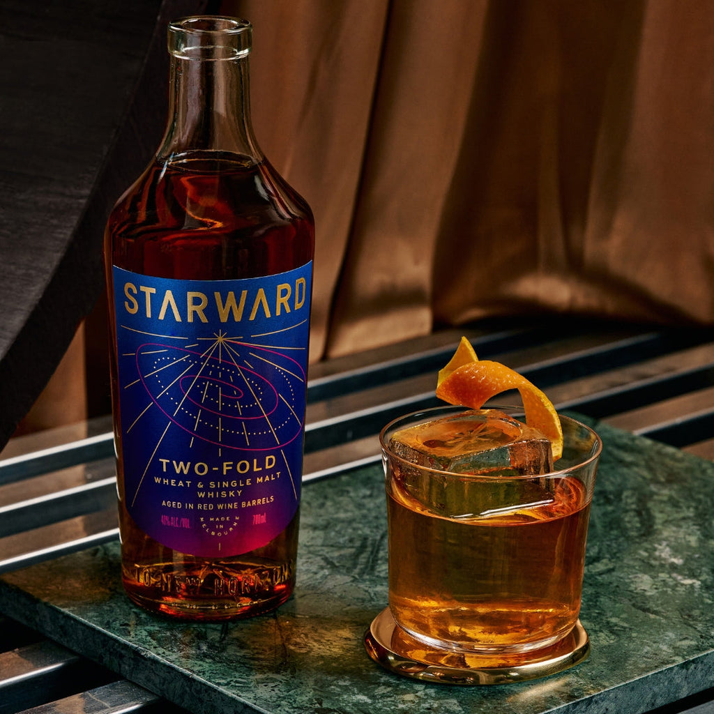 Starward Two-Fold whisky bottle with a cocktail on a marble surface