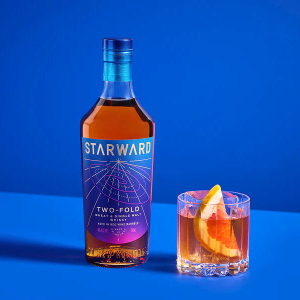 Starward Two-Fold whiskey bottle with a cocktail on a blue background