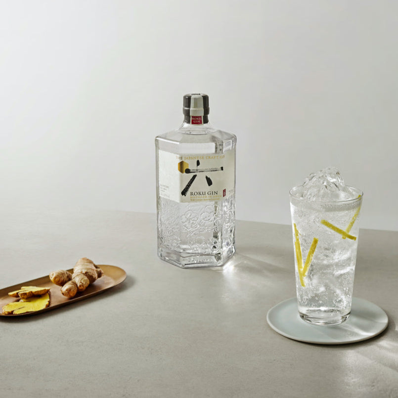 Load image into Gallery viewer, Bottle of Roku Gin with a glass of gin and tonic on a light surface.