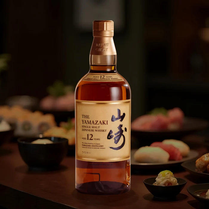 Yamazaki whisky bottle on a table with sushi in the background