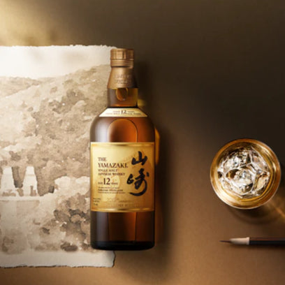 Bottle of Yamazaki whisky with a glass and decorative elements on a textured surface