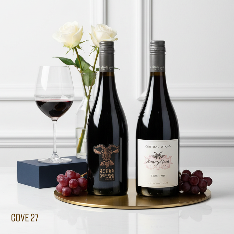 Load image into Gallery viewer, Two NANNY GOAT PINOT NOIR wine bottles on a tray with grapes and a glass, against a white wall.