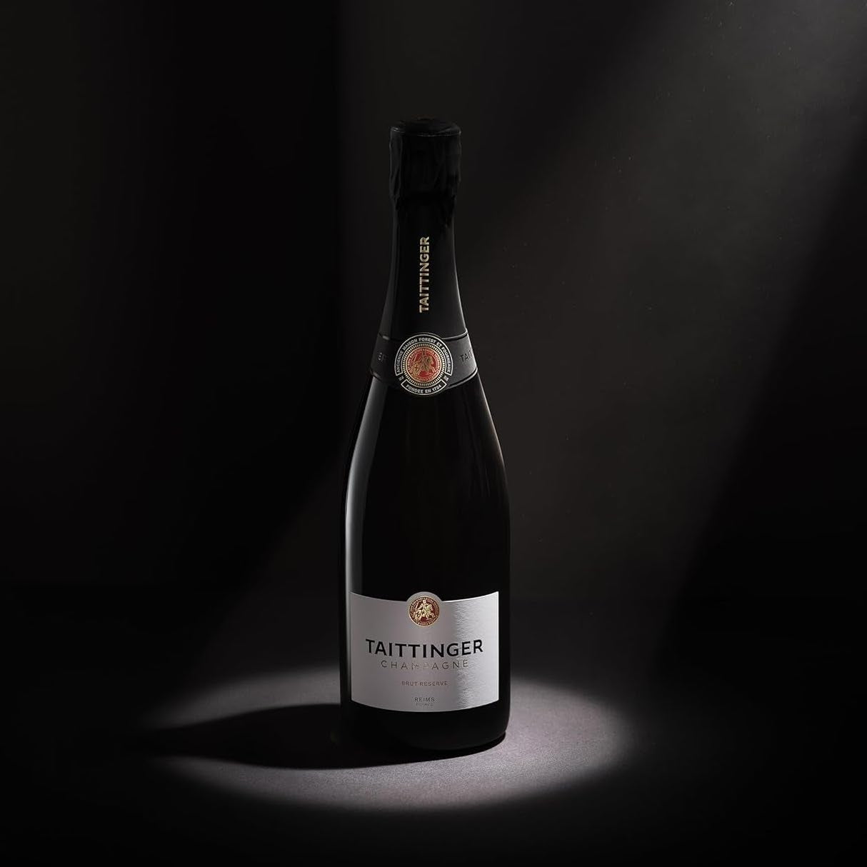 Load image into Gallery viewer, A bottle of Taittinger Brut Reserve Champagne on a dark background