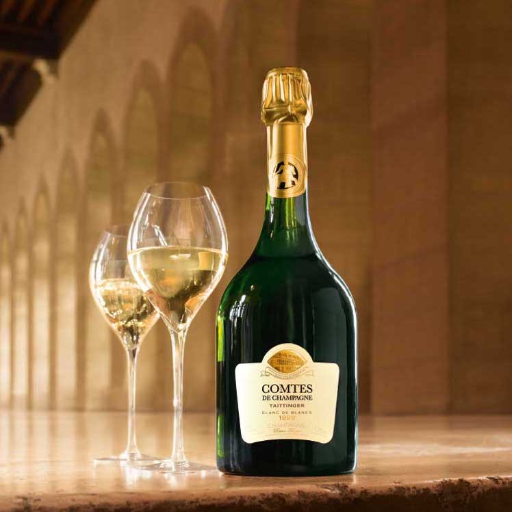Load image into Gallery viewer, A bottle of Taittinger Comtes de Champagne Blanc de Blancs and two champagne glasses on a marble table