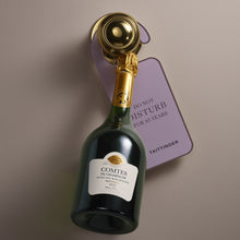 Load image into Gallery viewer, Champagne bottle with gold foil and purple tag on a gray background