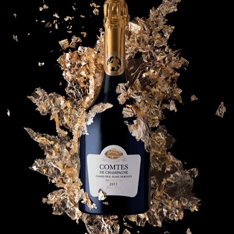 Load image into Gallery viewer, A bottle Taittinger Comtes de Champagne Blanc de Blancs with golden leeaves in the background