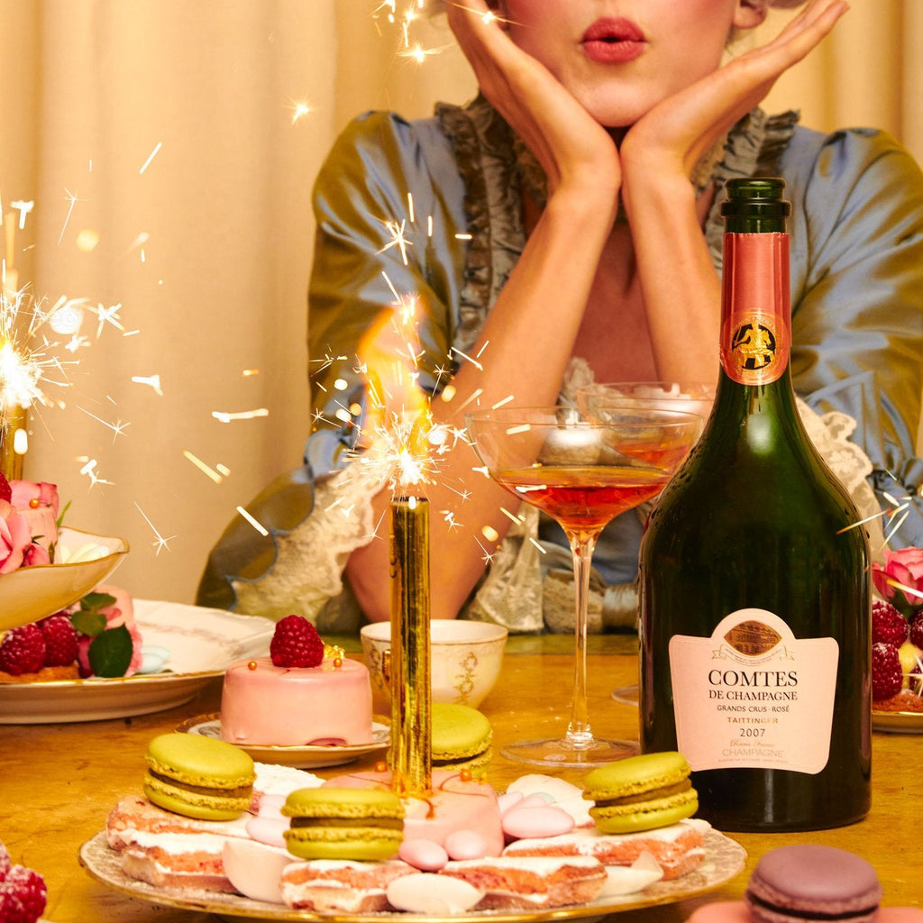 Woman celebrating with champagne and pastries at a table