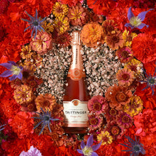 Load image into Gallery viewer, Bottle of Taittinger champagne surrounded by a vibrant floral wreath on a red background
