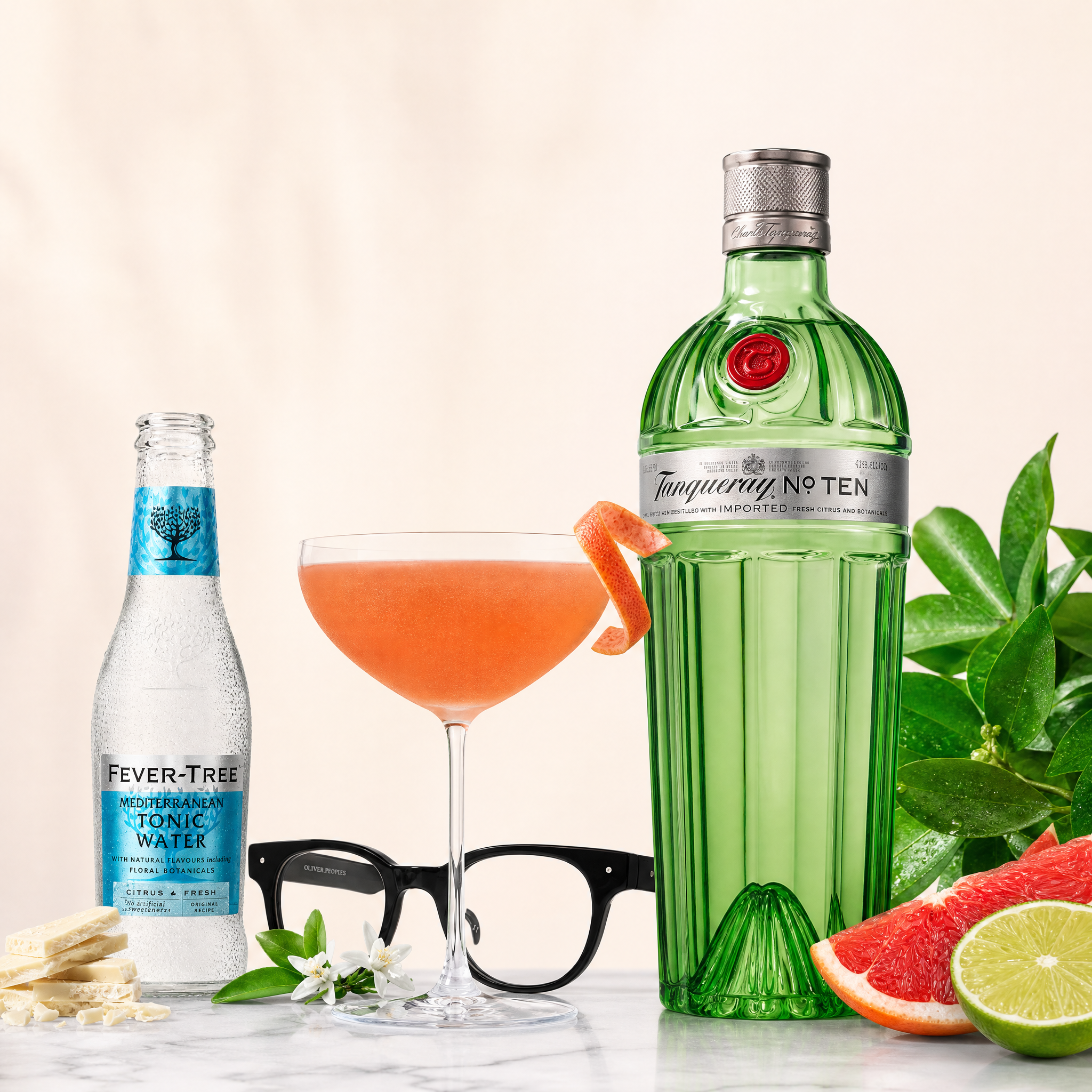 Load image into Gallery viewer, Tanqueray No. Ten gin bottle with a cocktail, tonic water, and garnishes on a light background