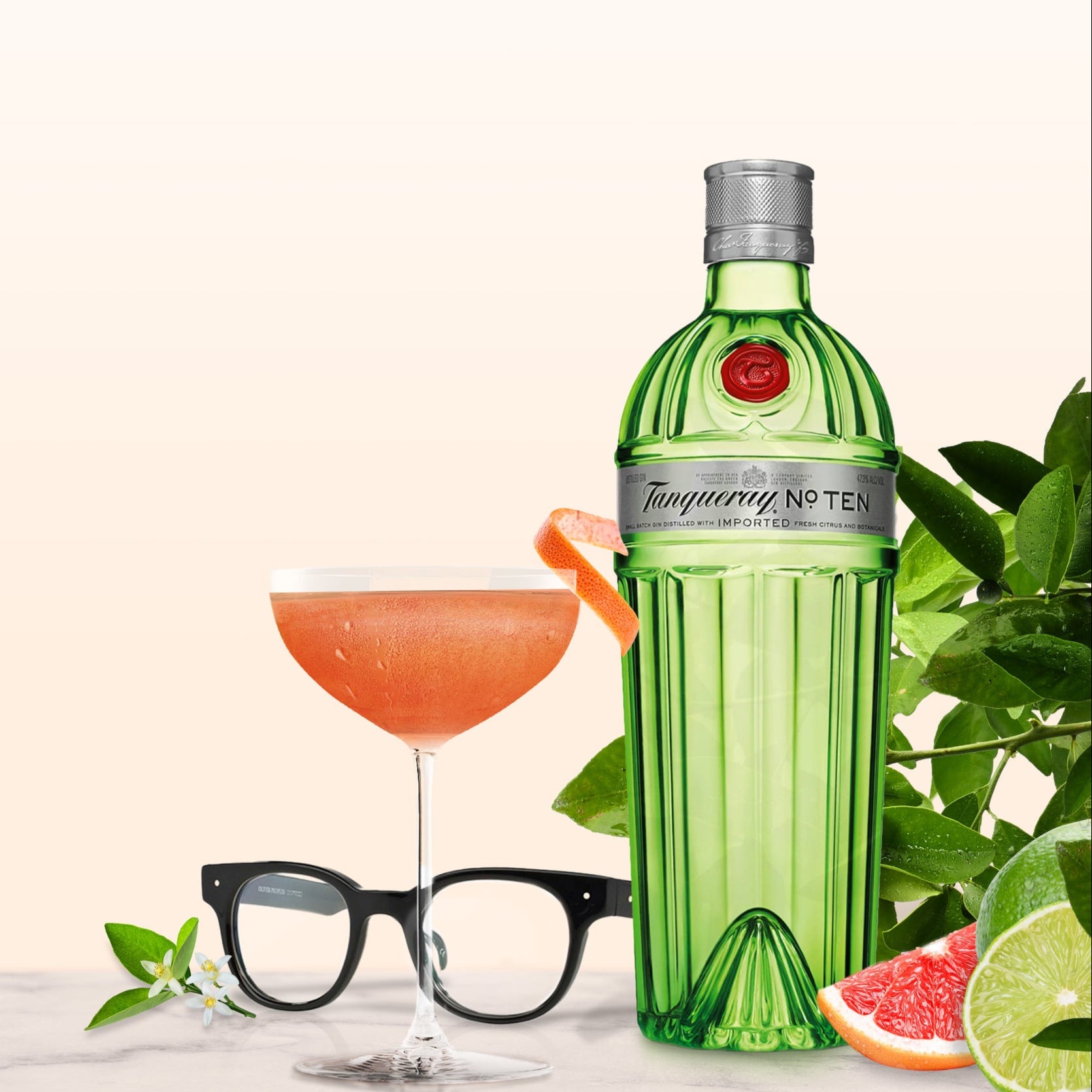 Load image into Gallery viewer, Tanqueray No. Ten gin bottle with a cocktail and garnishes on a light background