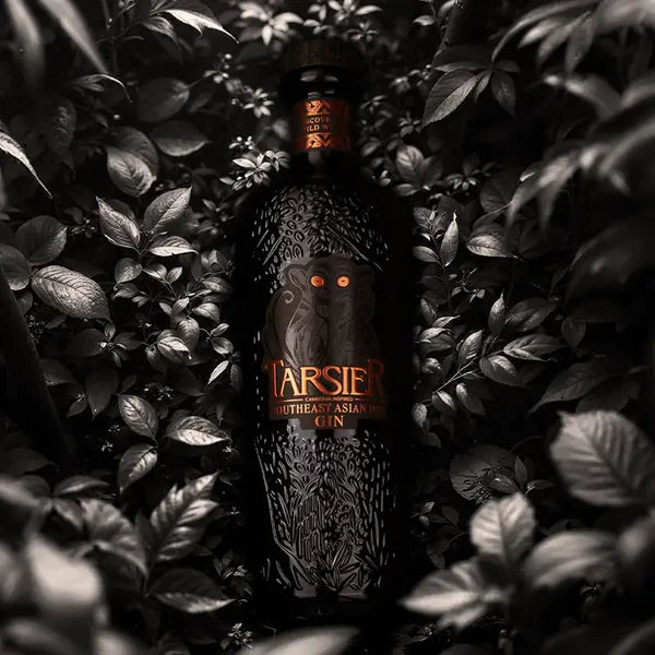 Load image into Gallery viewer, Bottle of Tarsier Southeast Asian Dry gin surrounded by leaves