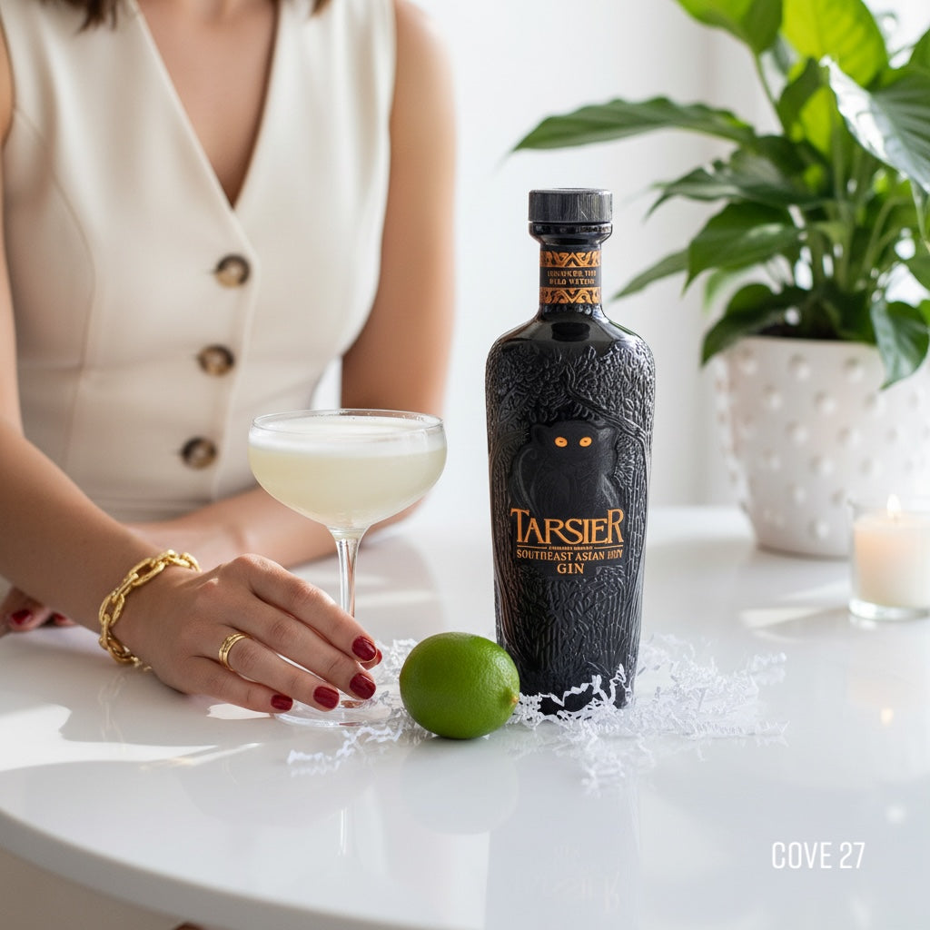Load image into Gallery viewer, Bottle of Tarsier Southeast Asian Dry gin with a cocktail and lime on a table