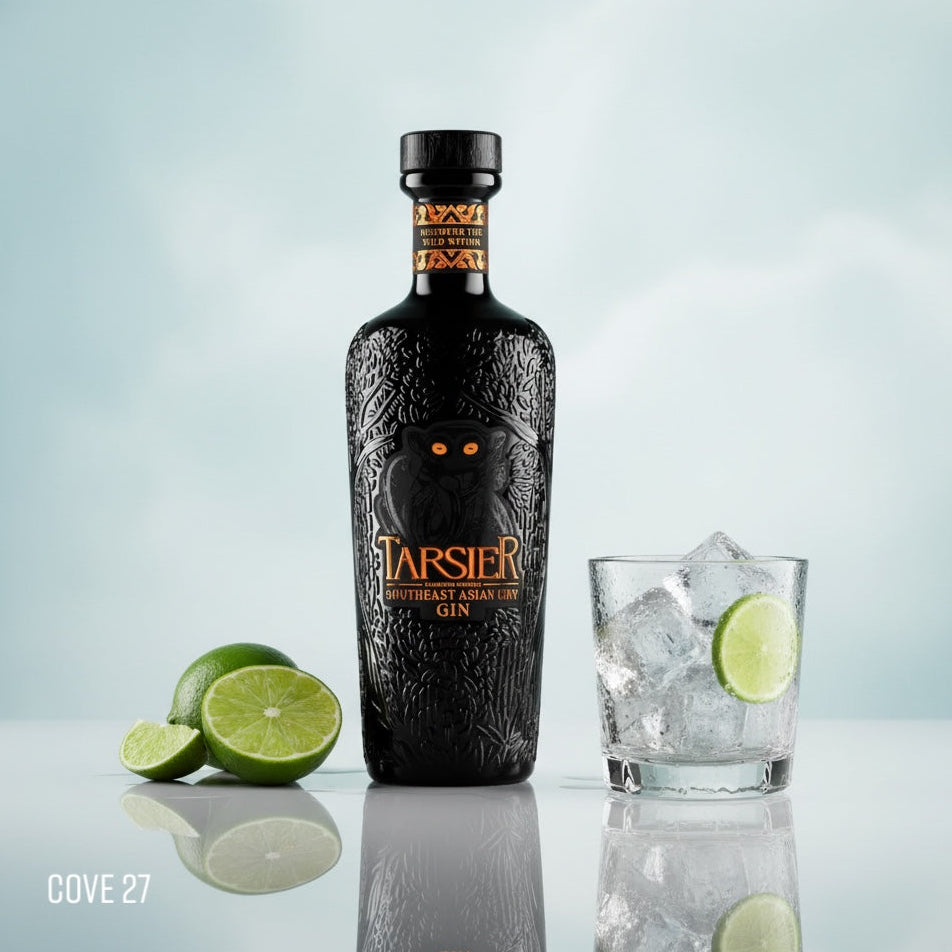 Load image into Gallery viewer, Bottle of Tarsier Southeast Asian Dry gin with a glass of ice and lime on a reflective surface
