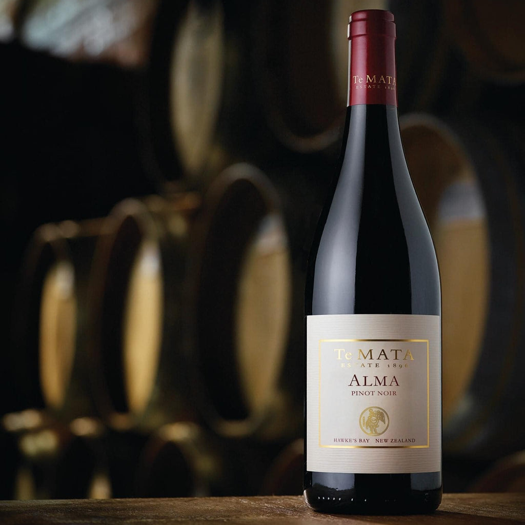 Wine bottle with 'Alma' label in a wine cellar setting