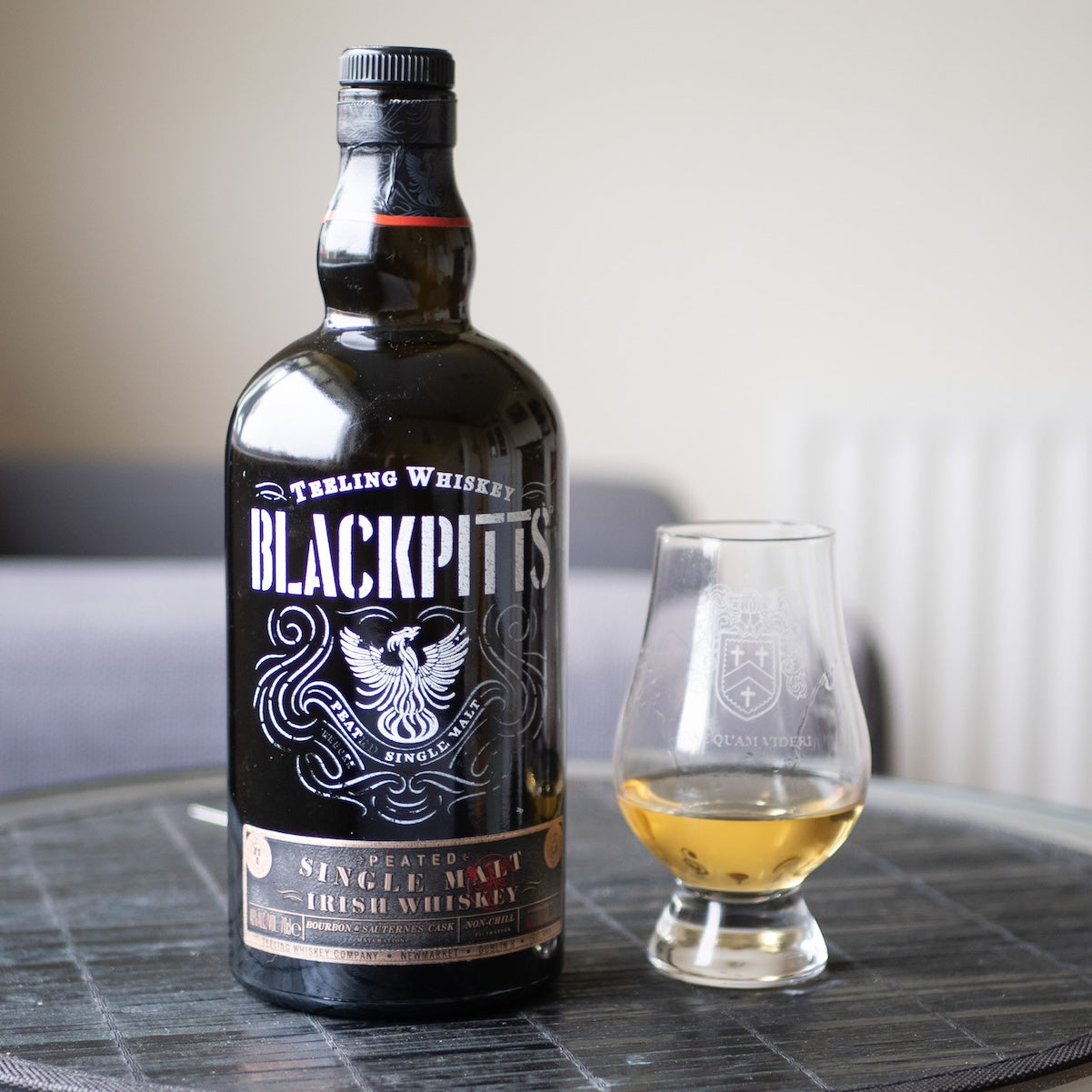 Load image into Gallery viewer, A bottle of Teeling Irish whiskey on a table with a tumbler of neat whiskey beside it